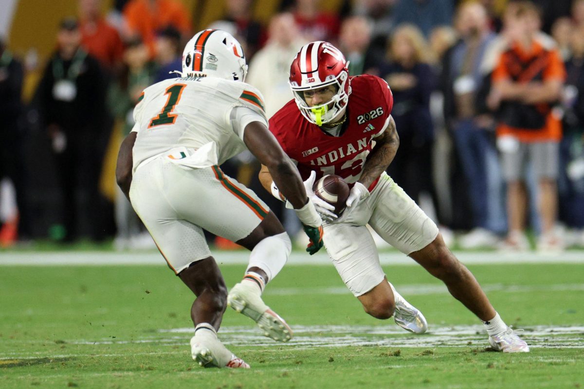 Jan 19, 2026; Miami Gardens, FL, USA; Indiana Hoosiers wide receiver Elijah Sarratt (13) makes a catch against Miami Hurricanes linebacker Mohamed Toure (1) in the second half during the College Football Playoff National Championship game at Hard Rock Stadium. Mandatory Credit: Nathan Ray Seebeck-Imagn Images