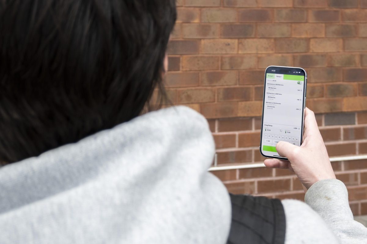An underage student places bets on the Fliff app, utilized by many for its loopholes that enable sports gambling under 21. Photo illustration by Bridget Lord for The Mass Media